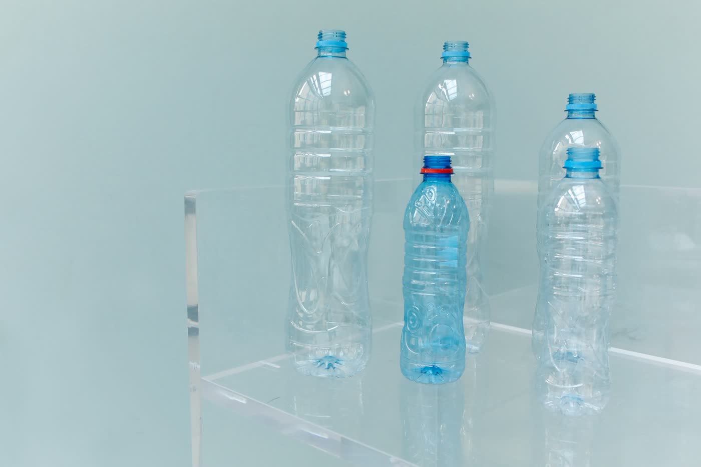 Clear empty PET bottles on a glass shelf